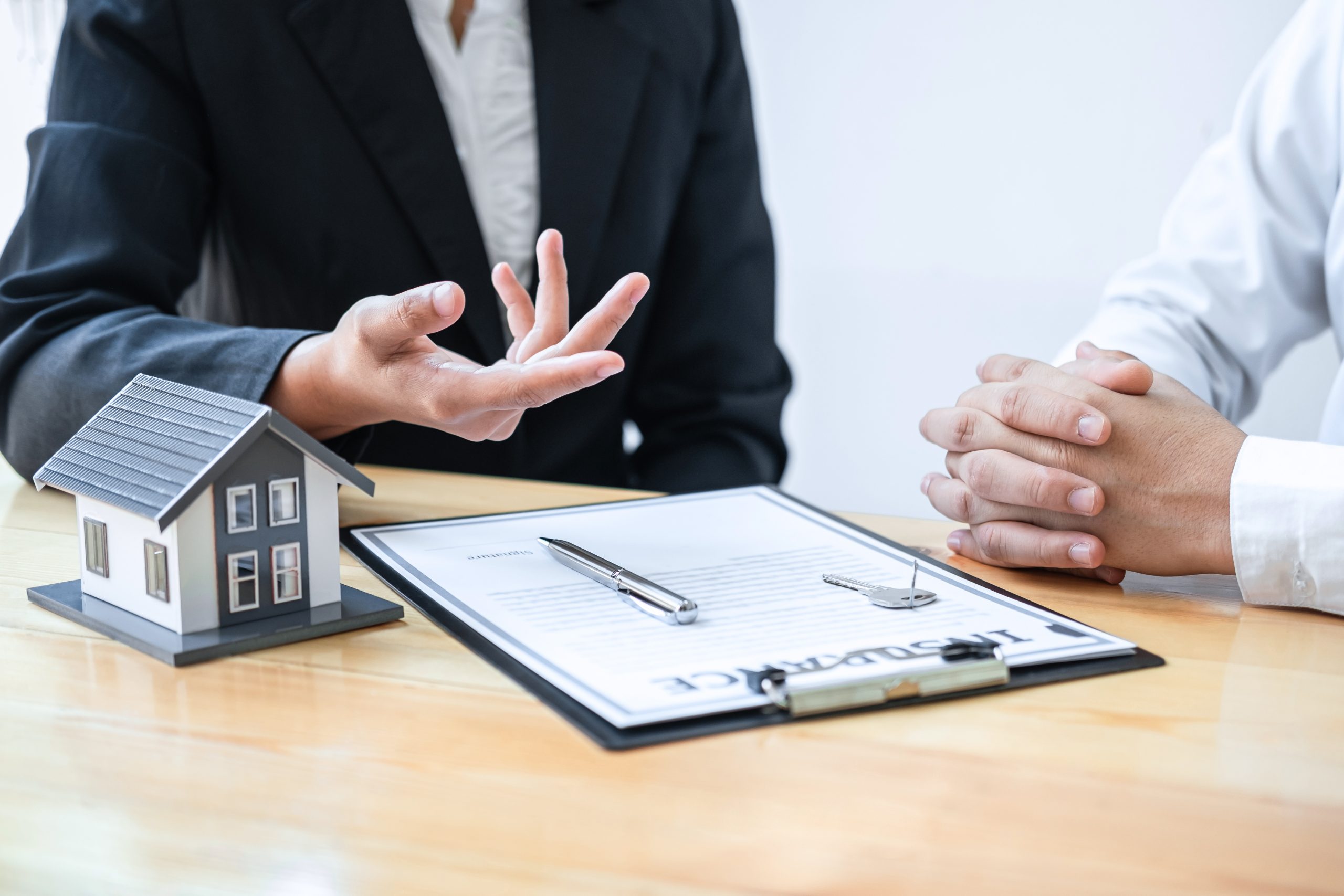 Estate agent are presenting home loan and giving house to client