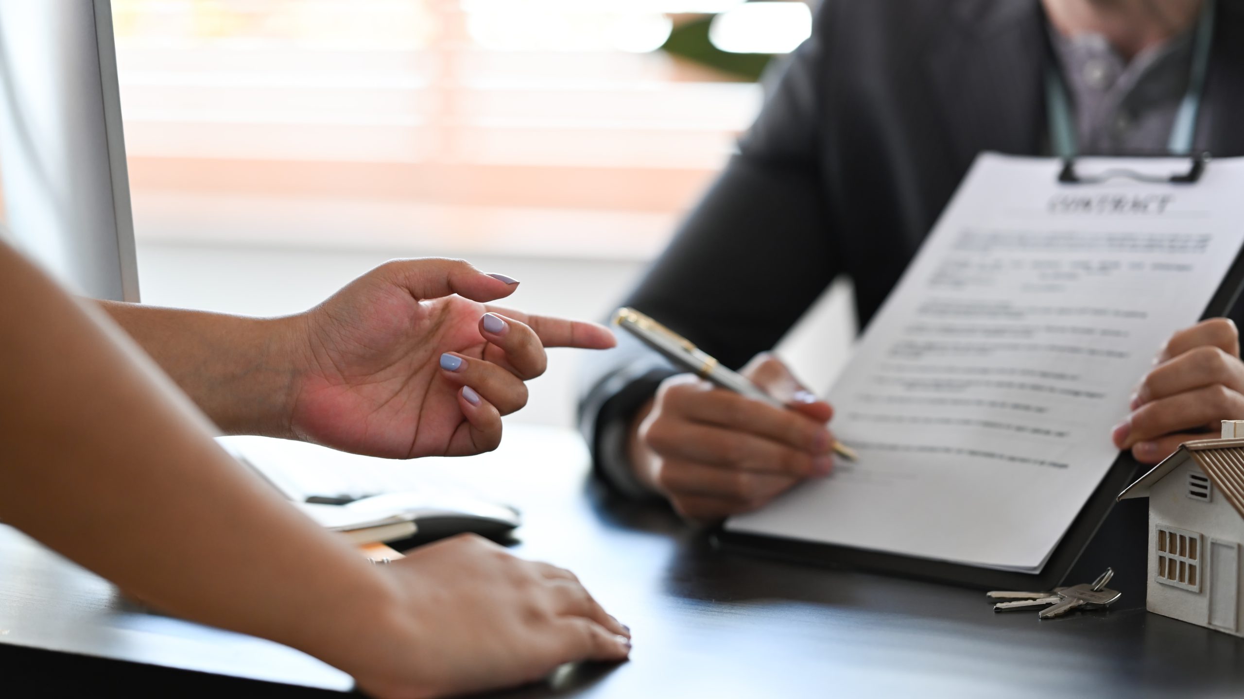 Financial advisor consulting with clients about new house and showing contract document.